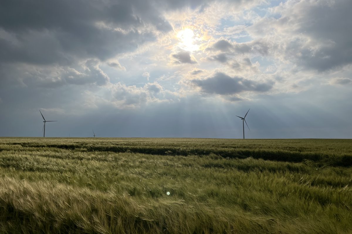 Wind turbines under a breaking storm sky
